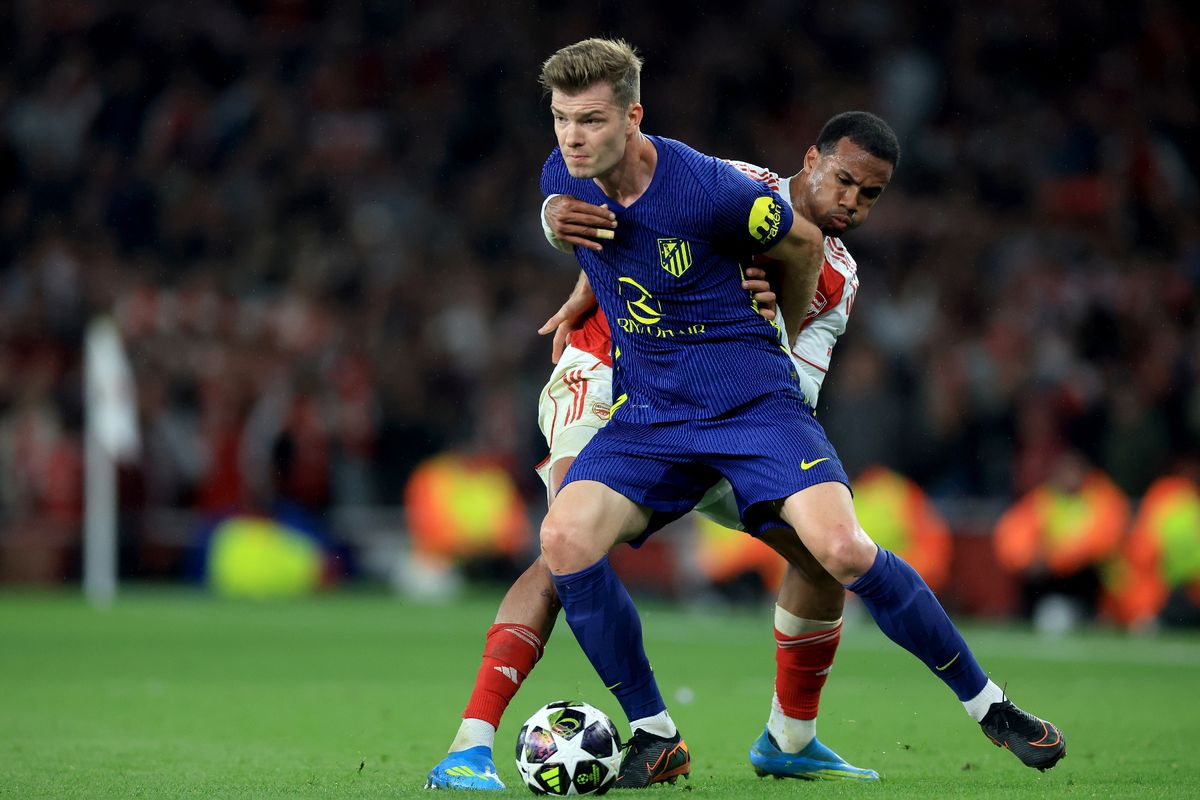 Arsenal and Atletico Madrid players during a UEFA Champions League match, reflecting Arsenal's defensive transfer ambitions