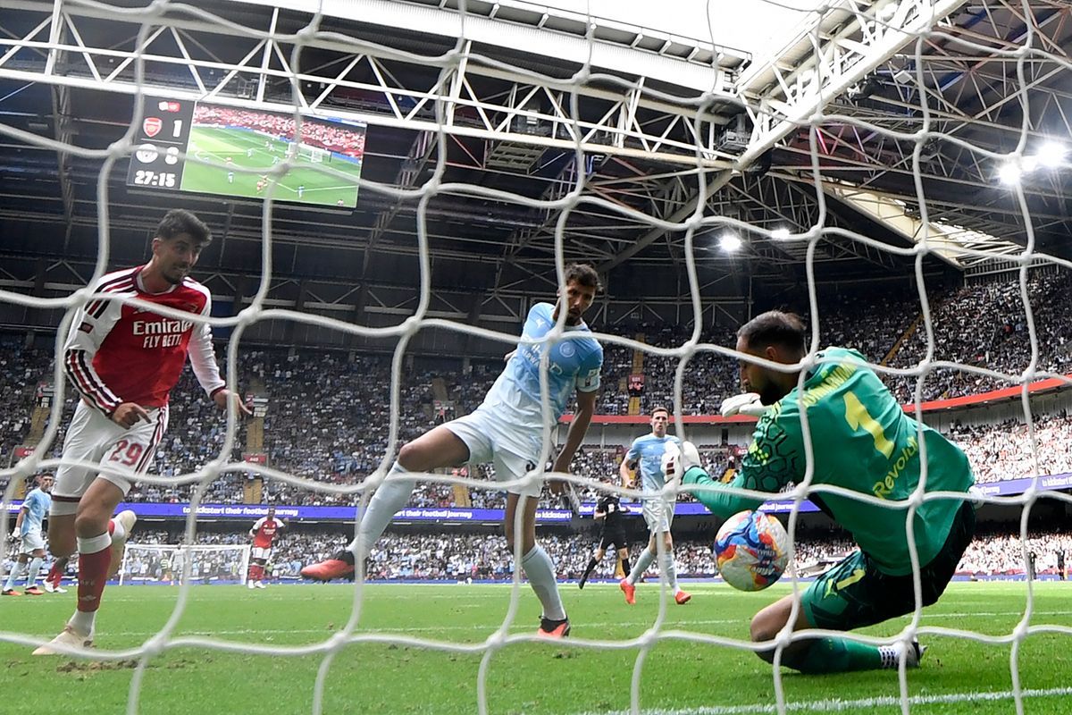 Myles Lewis-Skelly controlling the ball under pressure from Manchester City players